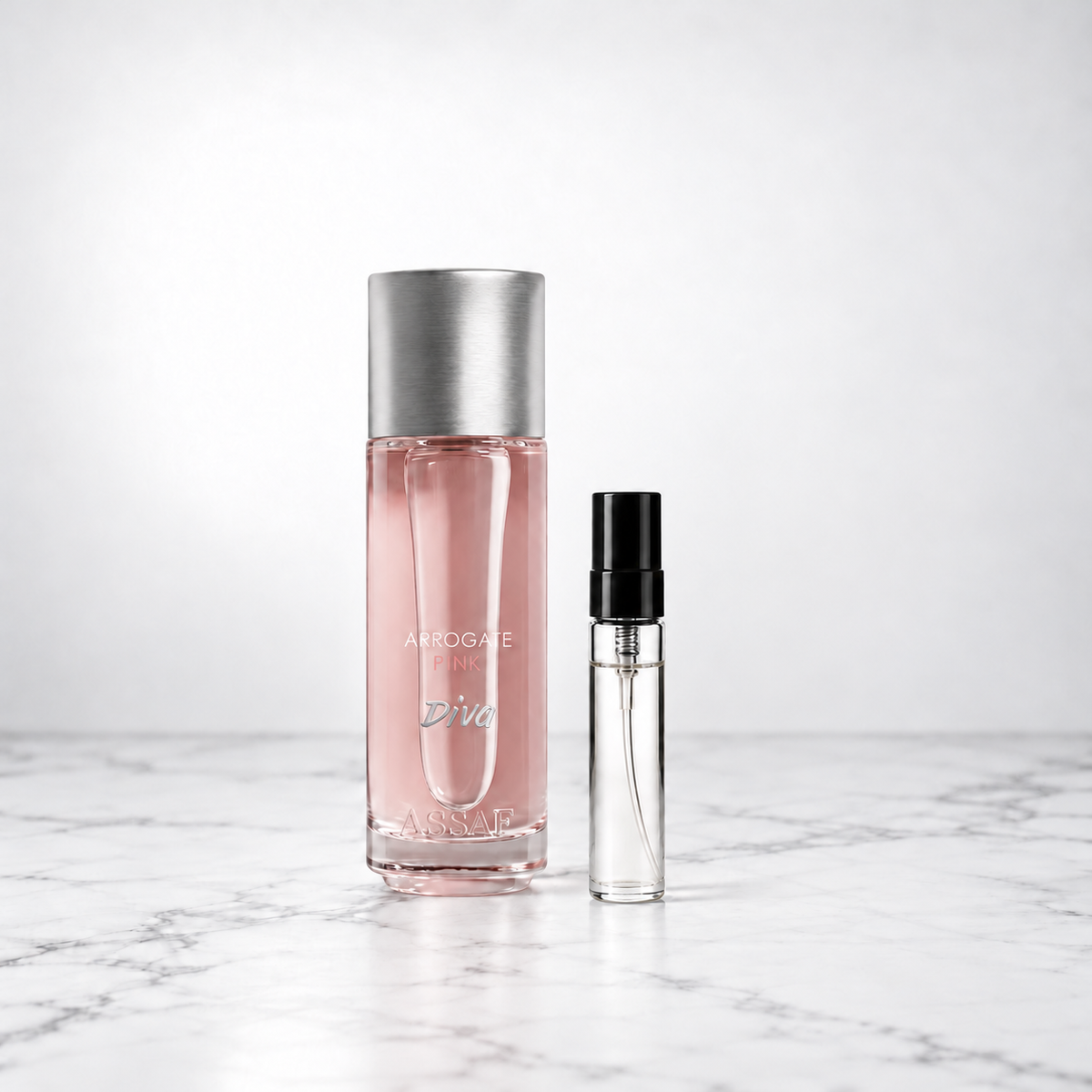 Arrogate Pink Diva by Assaf bottle beside a capped sample decant on white marble