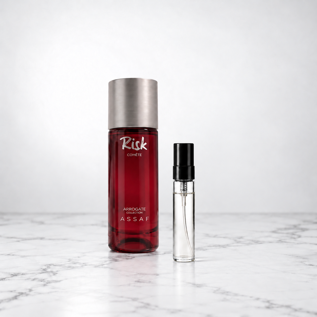 Risk Comete by Assaf bottle beside a capped sample decant on white marble