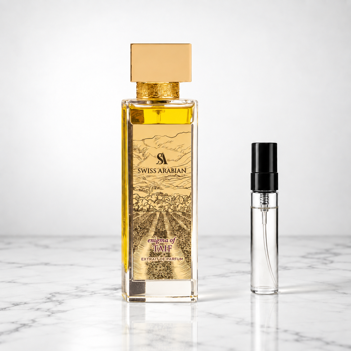 enigma of taif perfume bottle beside a 5ml decant on white marble