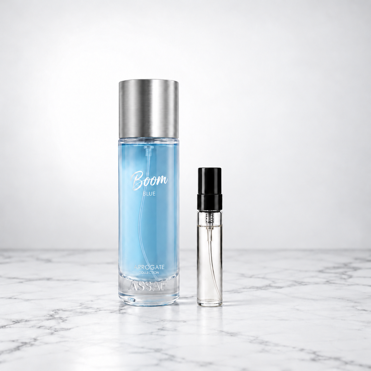 Boom Blue by Assaf bottle beside a capped sample decant on white marble