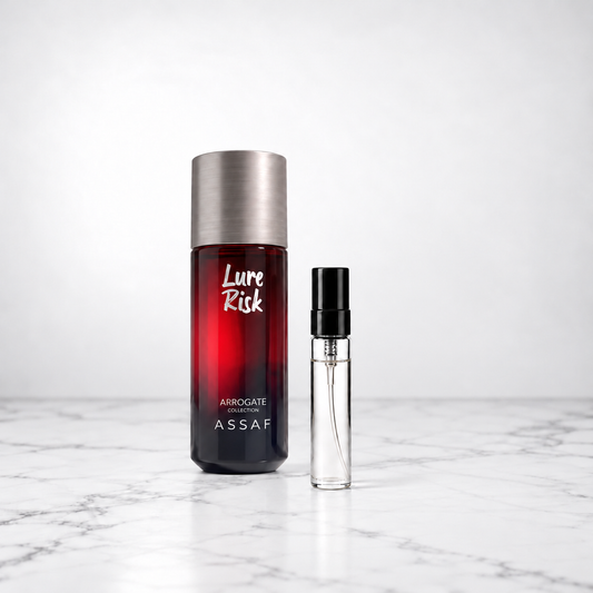 Lure Risk by Assaf bottle beside a capped sample decant on white marble