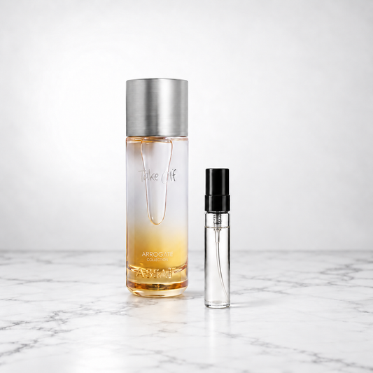 Take Off by Assaf bottle beside a capped sample decant on white marble