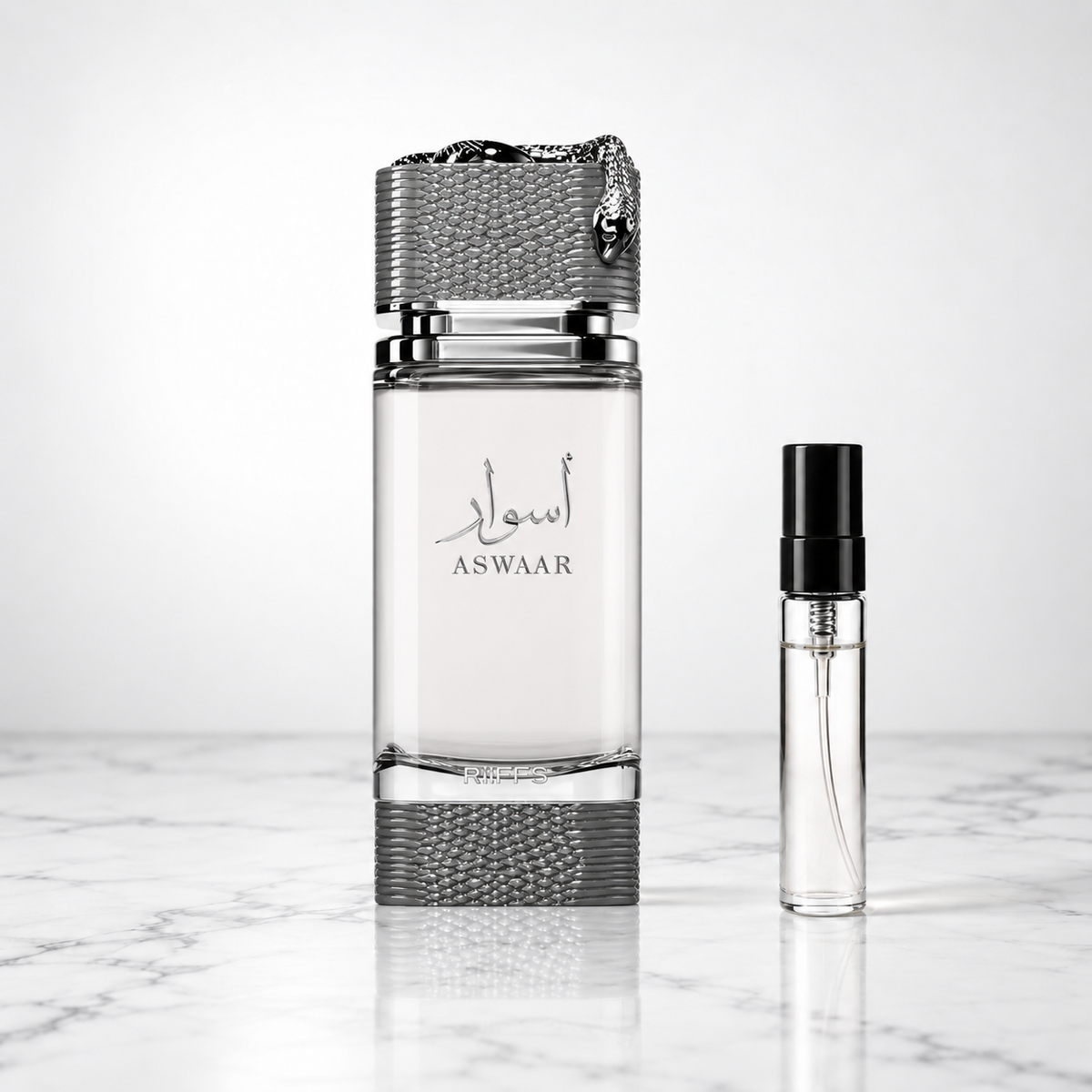 aswaar perfume bottle beside a 5ml decant on white marble