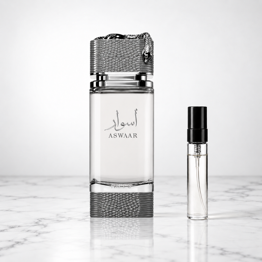 aswaar perfume bottle beside a 5ml decant on white marble
