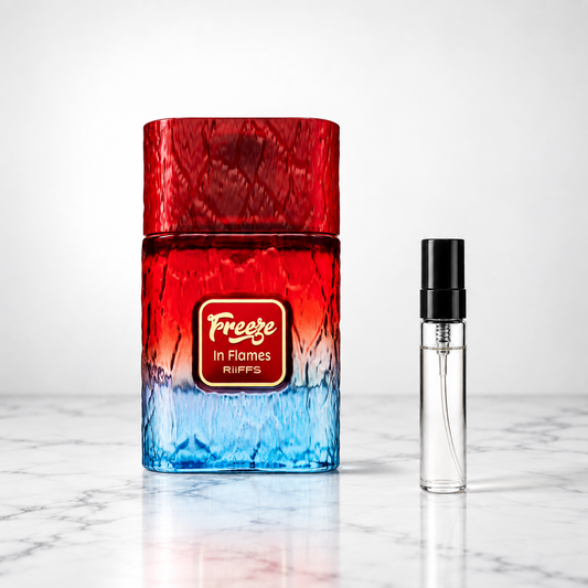 freeze in flames perfume bottle beside a 5ml decant on white marble