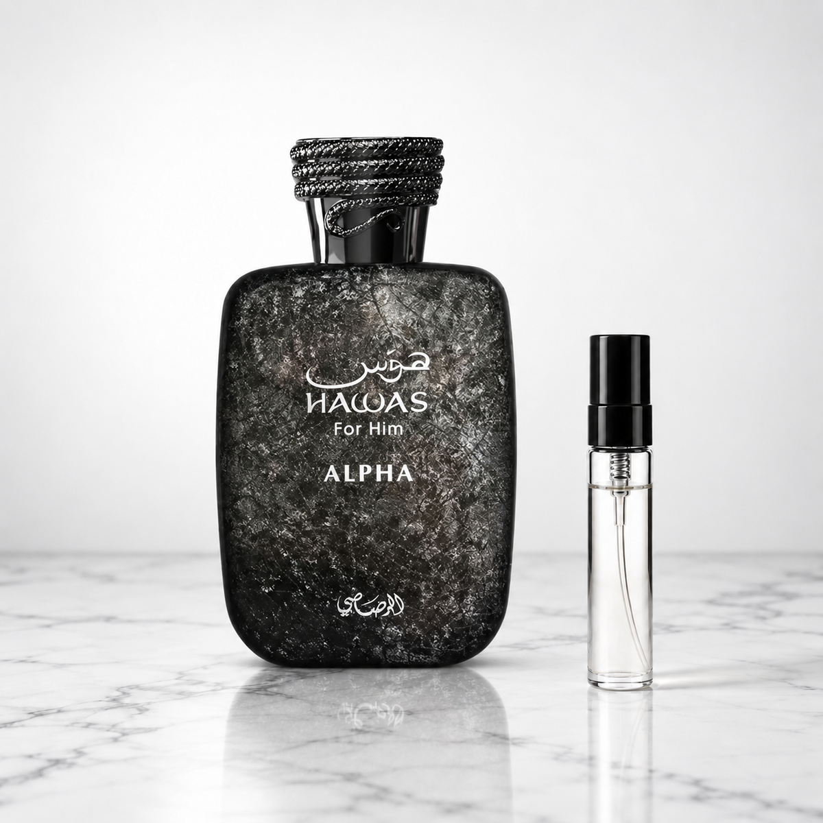 hawas alpha perfume bottle beside a 5ml decant on white marble