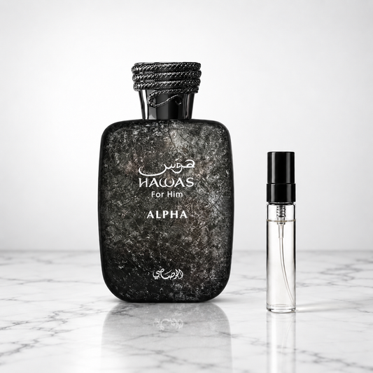 hawas alpha perfume bottle beside a 5ml decant on white marble