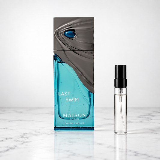 last swim perfume bottle beside a 5ml decant on white marble