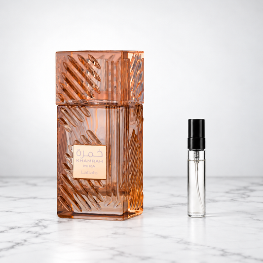 Khamrah Mira by Lattafa perfume bottle beside a sample decant on white marble