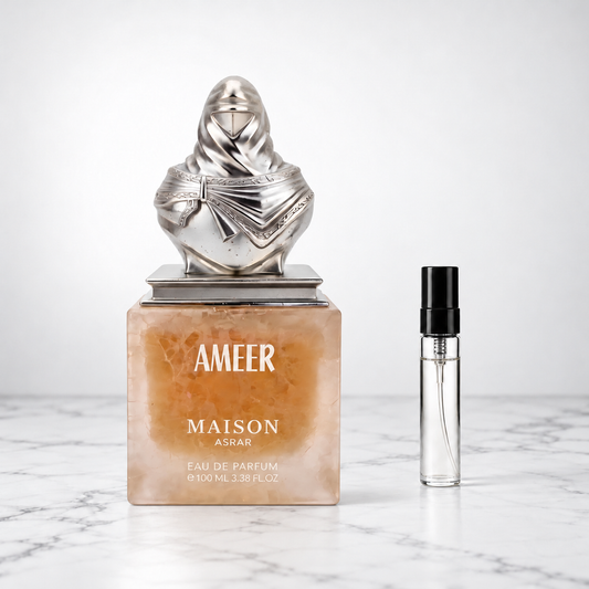 Ameer by Maison Asrar perfume bottle beside a sample decant on white marble