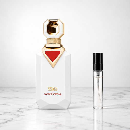 noble cedar perfume bottle beside a 5ml decant on white marble